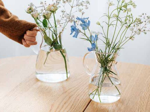 テーブルの上のフラスコ花瓶と草花