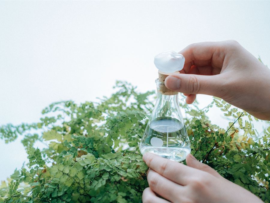 手に持った目盛り付きの水やり器