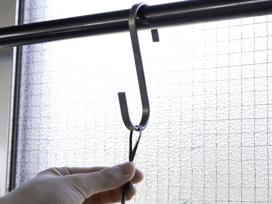 撥水加工の麻紐を窓辺のS字フックに掛けて吊るすようす