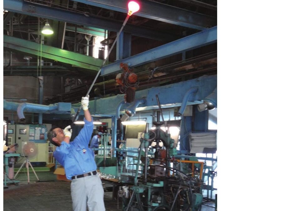 A glassblower shaping borosilicate glass by hand at the Koga Plant